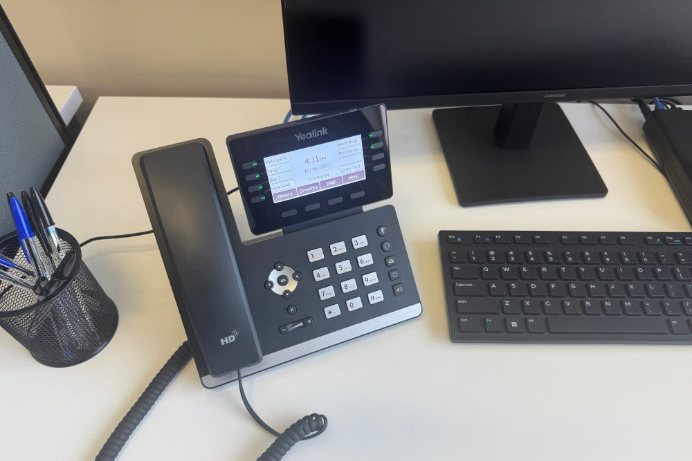 Photo of a business voip phone sitting on a desk.